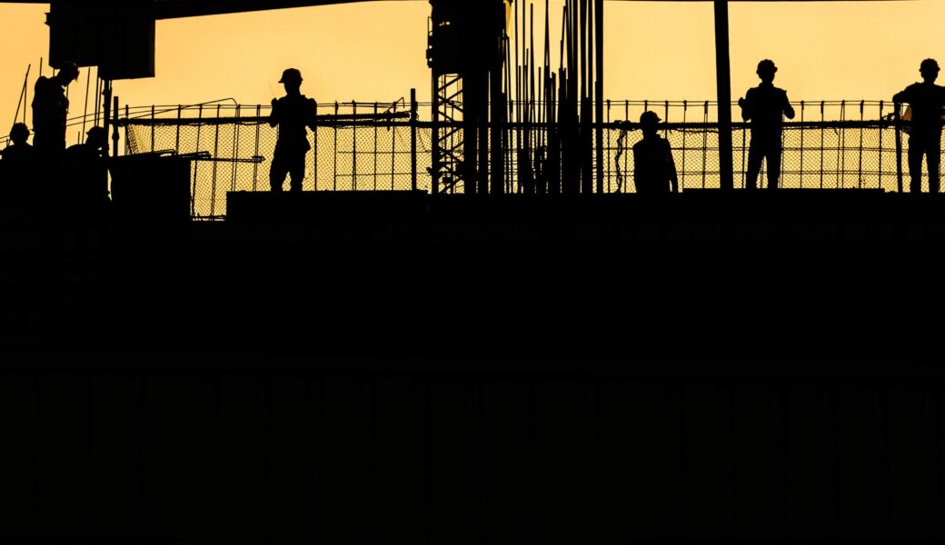 silhouette of a crane behind a building